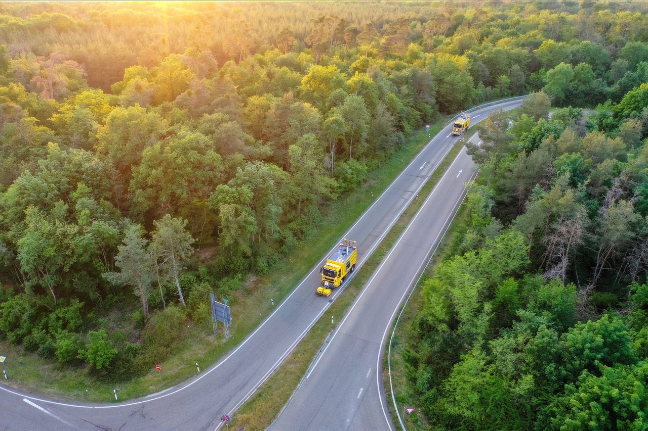 Abschleppfahrzeug auf einer Landstraße im Wald aus der Luft