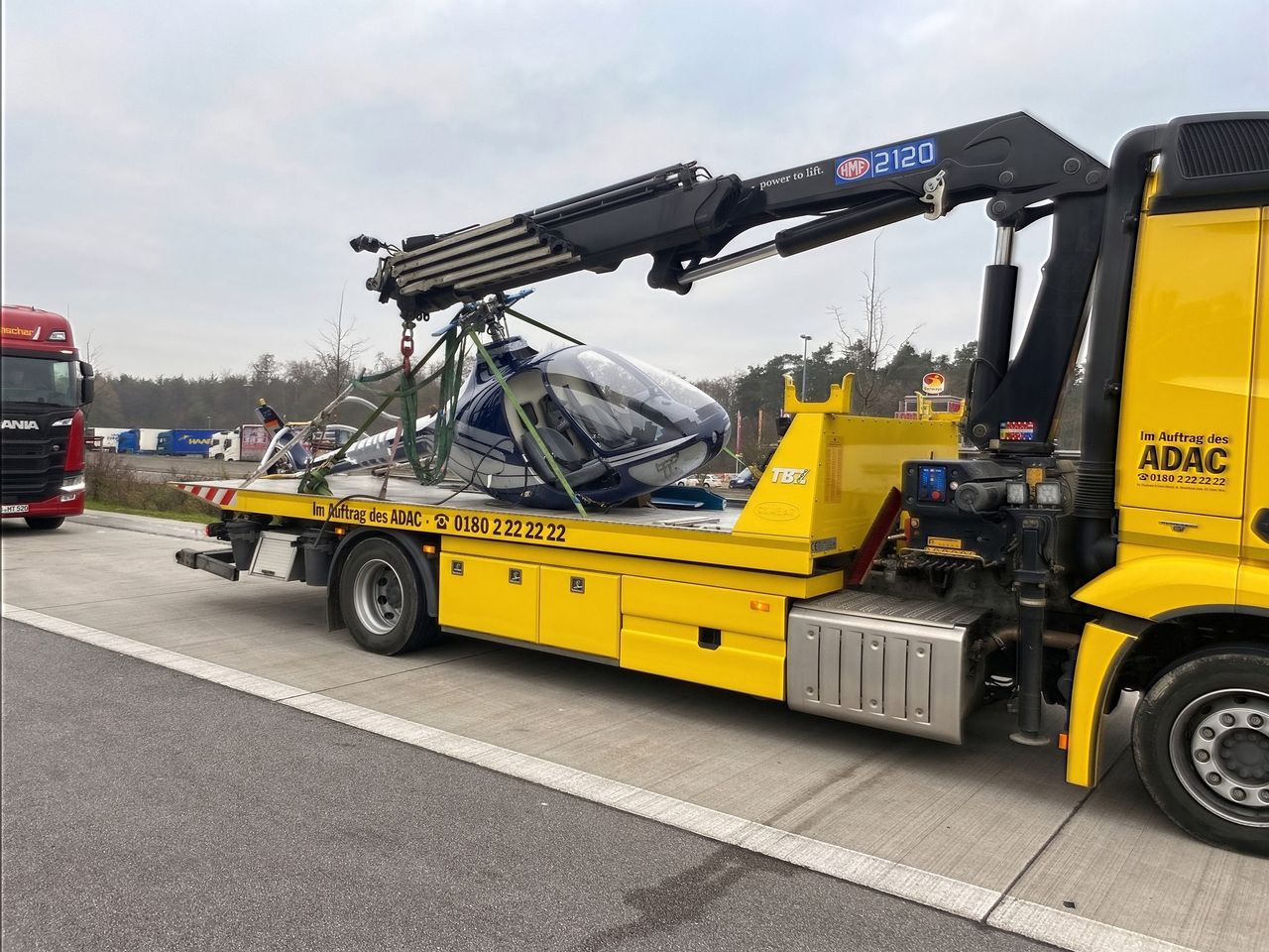 Hubschrauber auf dem Plateau eines Abschleppfahrzeugs der Höhl Gruppe in ADAC-Beschriftung