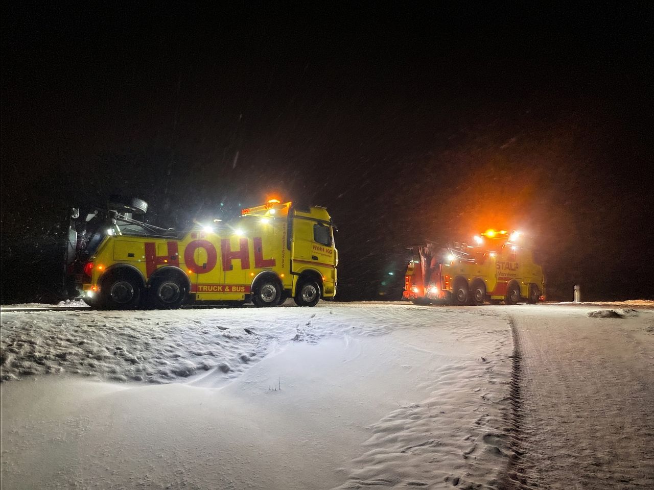 Bergefahrzeug bei der Bergung eines Lkw im Schneesturm auf der Autobahn